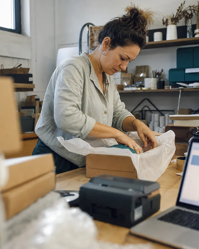Online store owner packing orders at a workbench